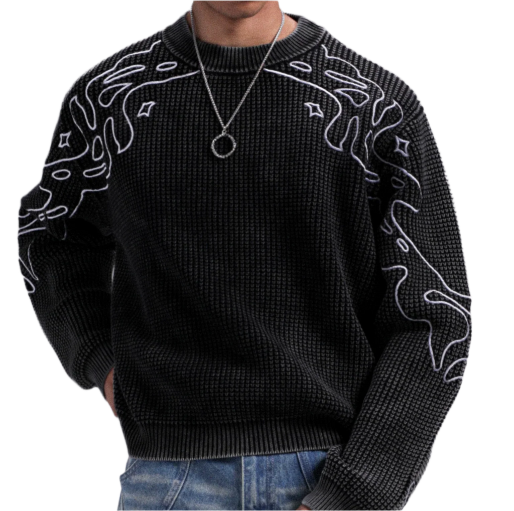 Black sweater with white patterns worn by a person on a gray background