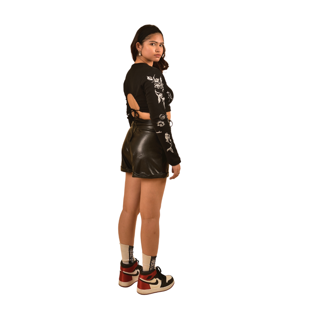 NVRFLD black club top with side cutouts and white floral designs paired with black leather shorts