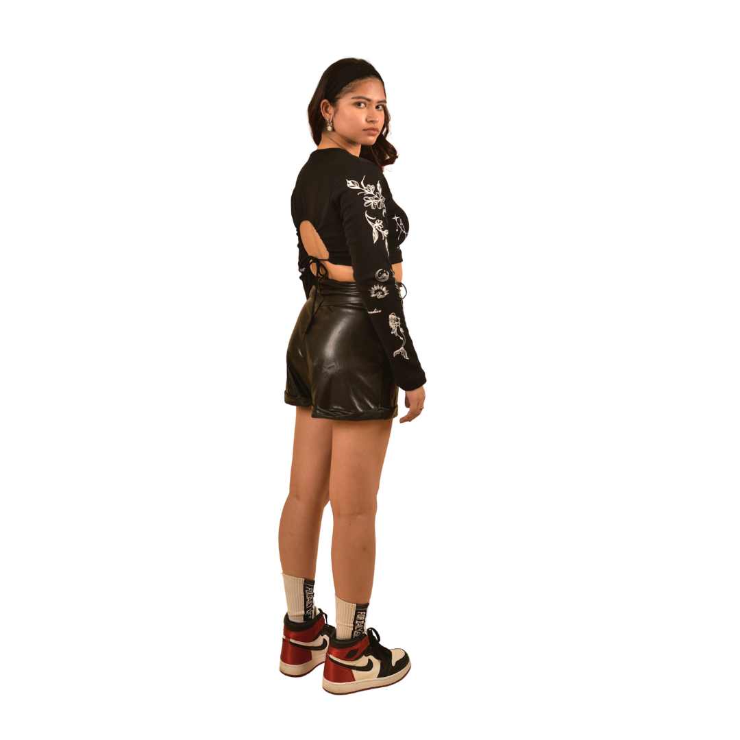 NVRFLD black club top with side cutouts and white floral designs paired with black leather shorts