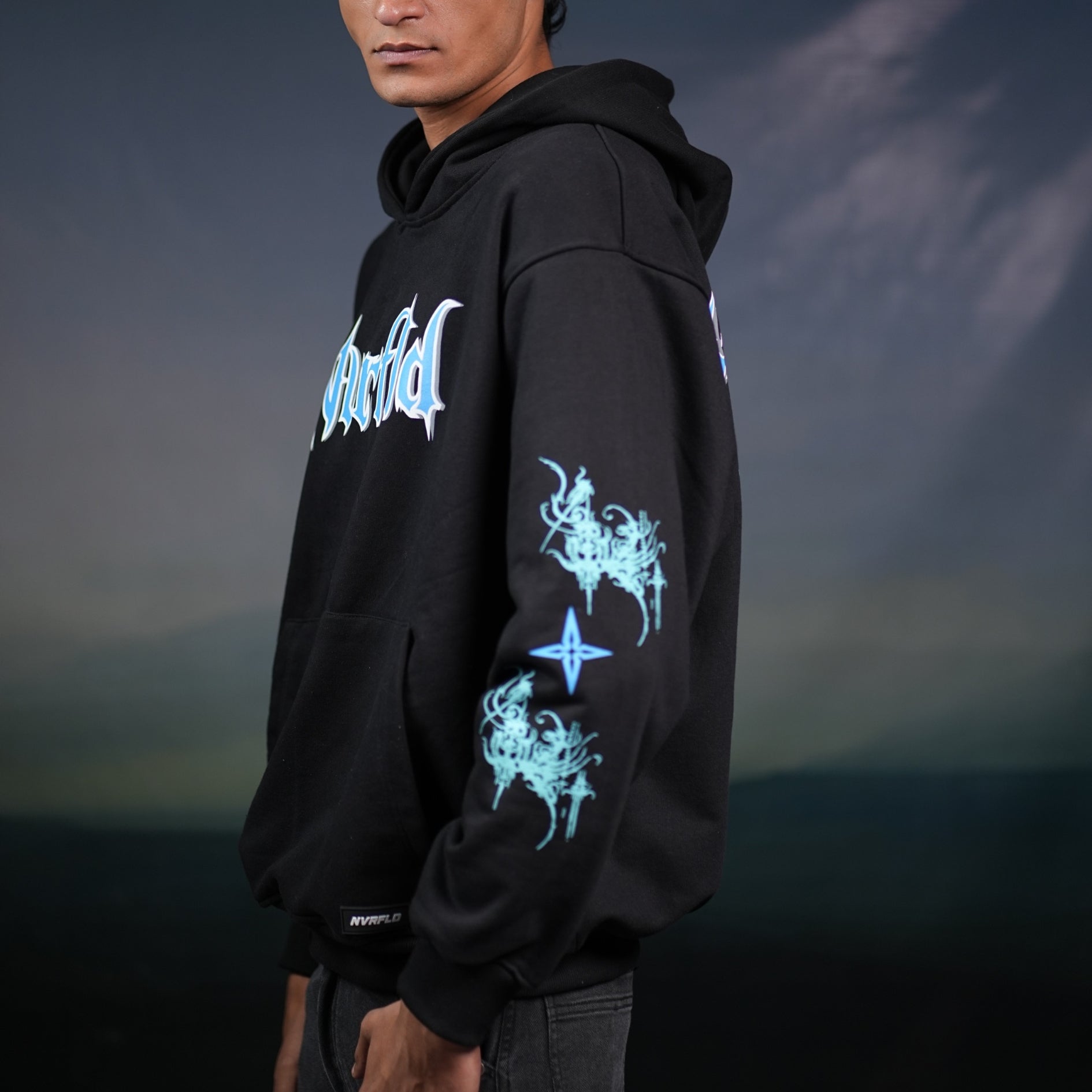 Black God hoodie statement piece by NVRFLD with blue graphic designs on sleeve and chest