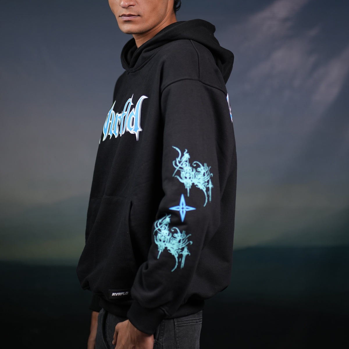Black God hoodie statement piece by NVRFLD with blue graphic designs on sleeve and chest