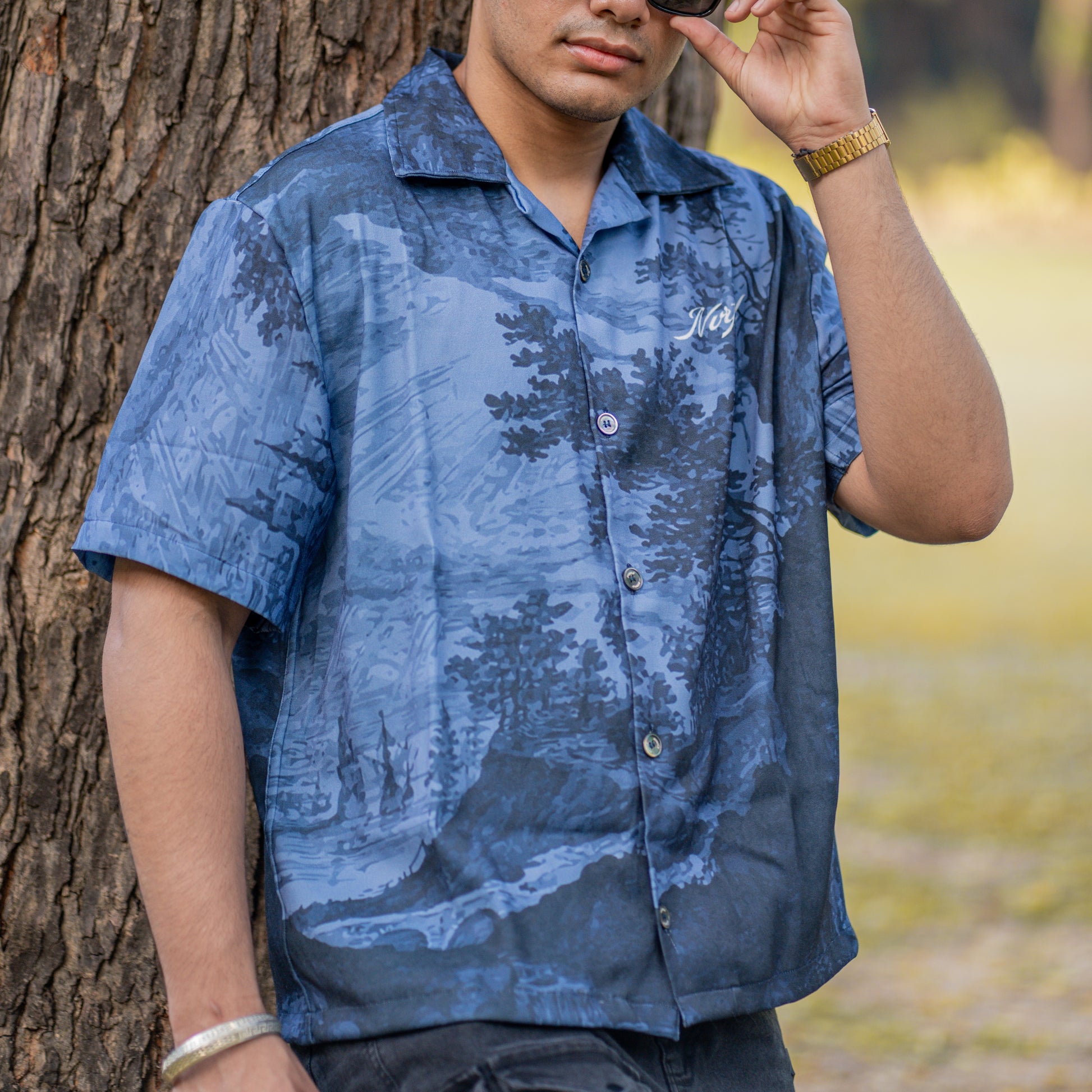 NVRFLD blue short sleeve contemporary statement shirt with nature print worn by man outdoors