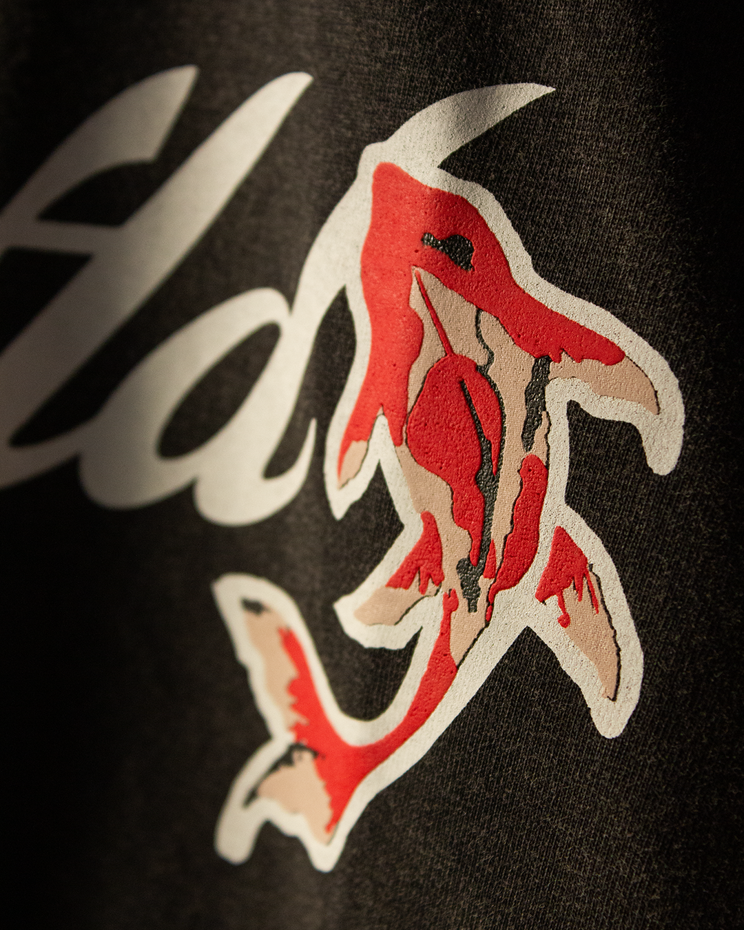 NVRFLD artistic tee with unique design featuring a red and white shark graphic on black fabric