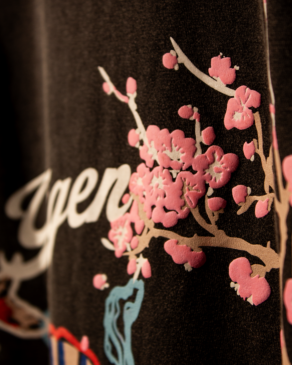 NVRFLD artistic tee with unique design featuring pink floral print on black fabric
