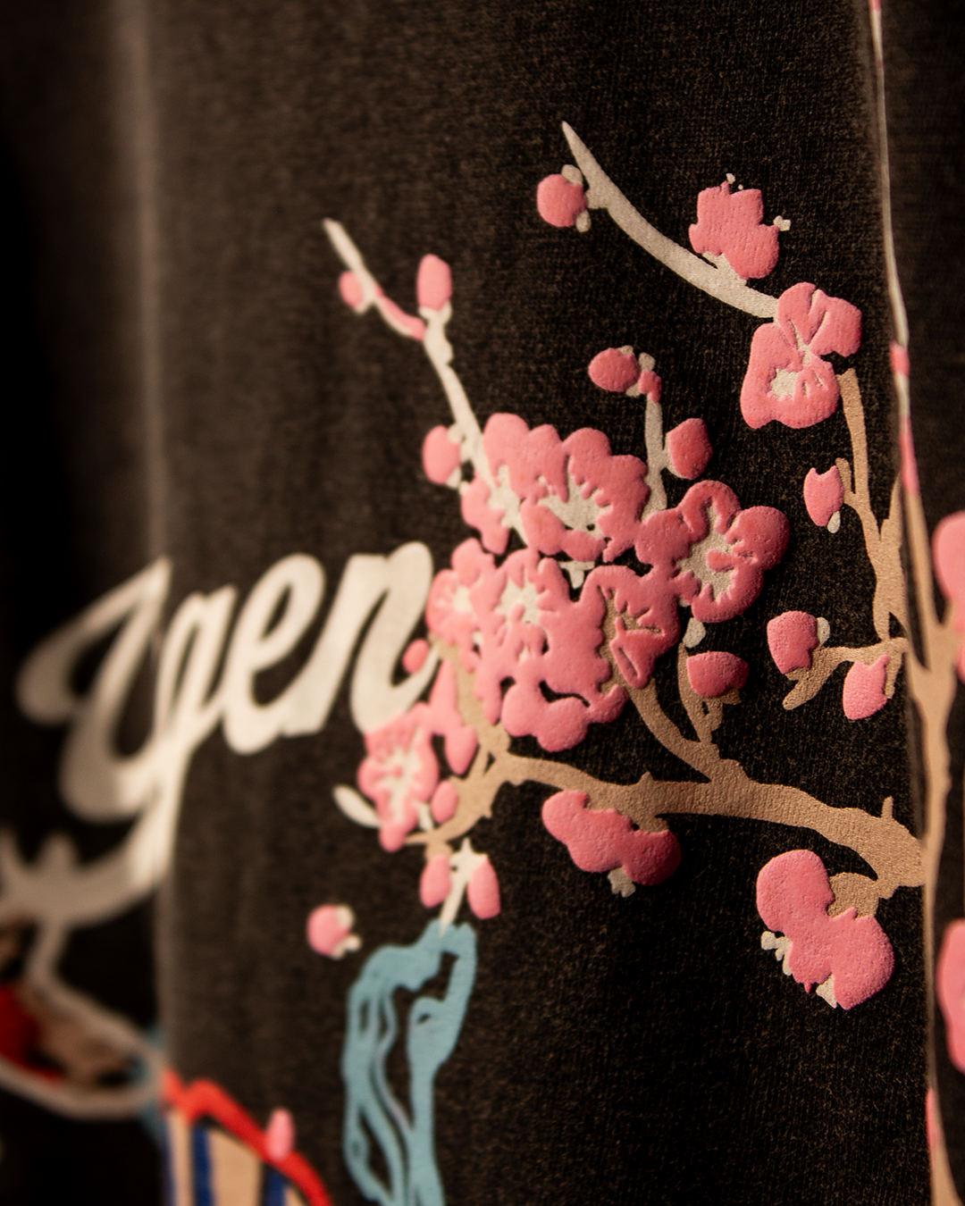 NVRFLD artistic tee with unique design featuring pink floral print on black fabric