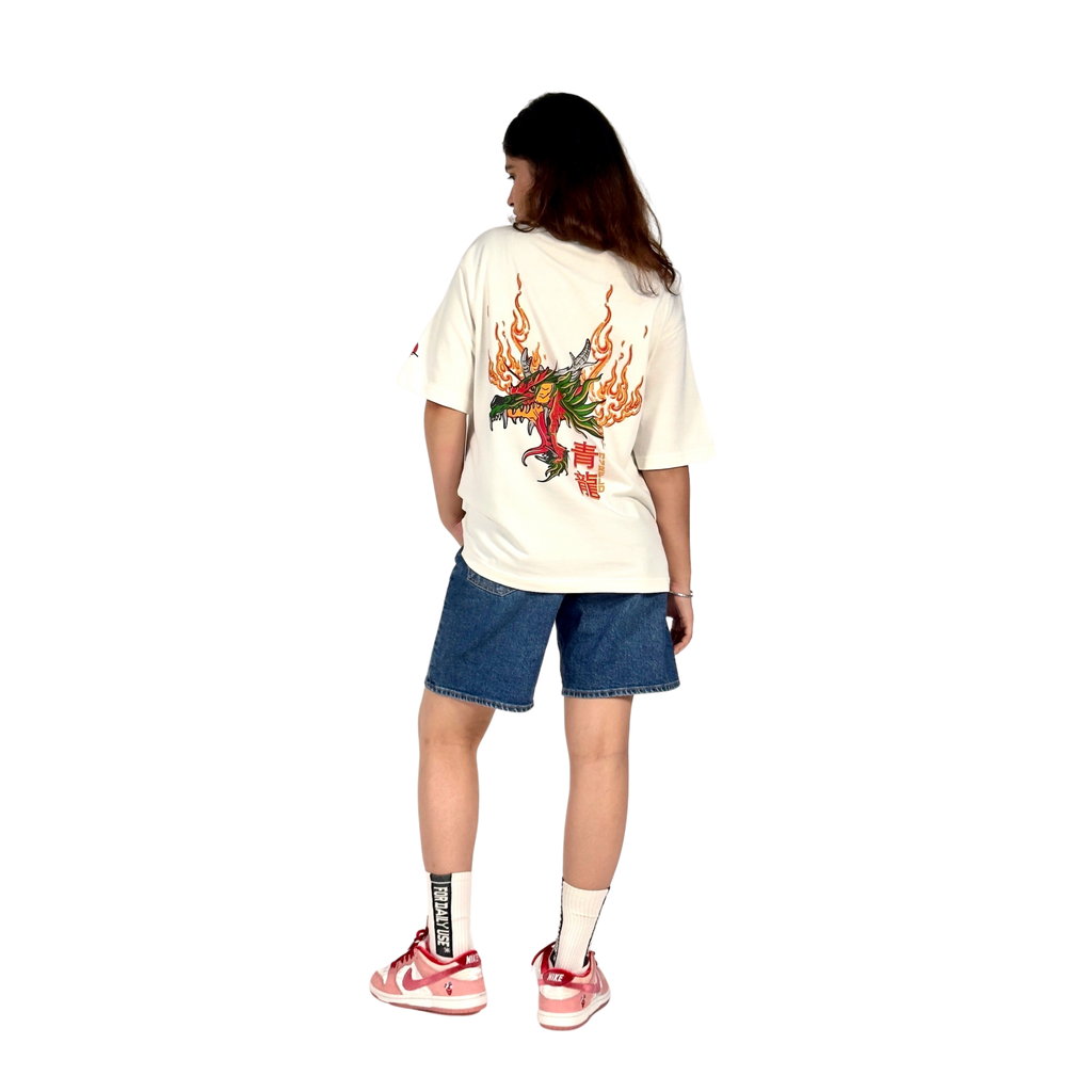 NVRFLD dragon graphic tee in white with fiery dragon design on the back worn with denim shorts