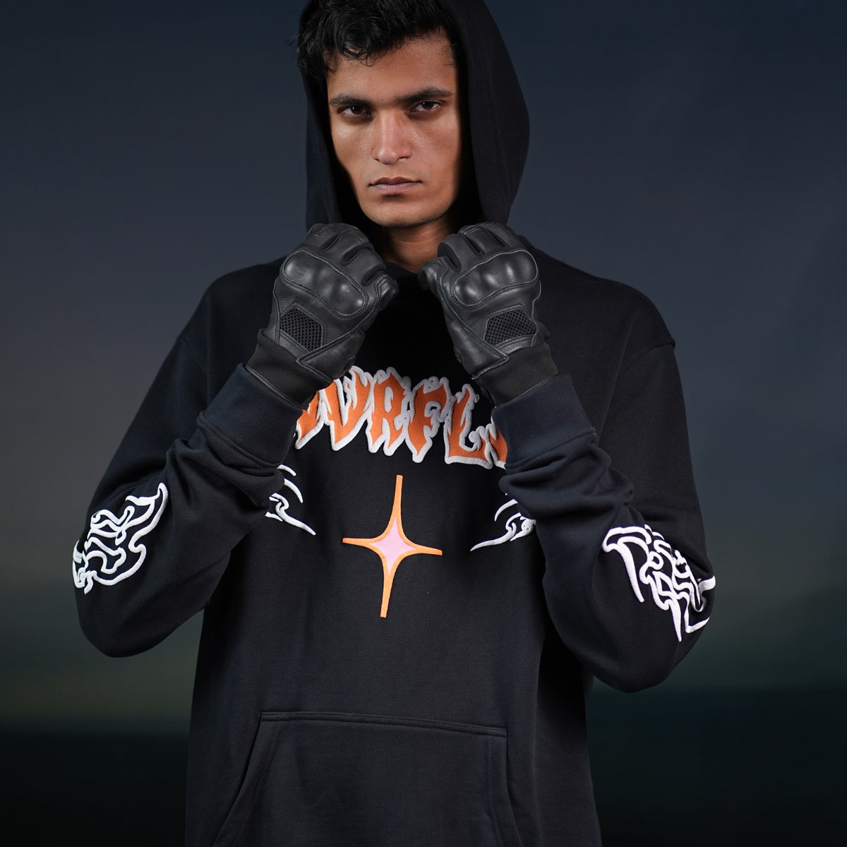 NVRFLD black graphic hoodie worn by model with hood up and black gloves